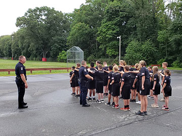 Kids being instructed how to stand in formation